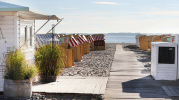 Strand mit Holzweg, Strandkörben und Blick aufs Meer am ATLANTIC Grand Hotel Travemünde.