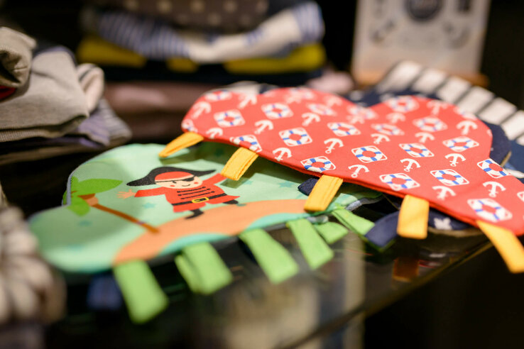 Colorful children's gloves with pirate and anchor designs on a table in the hotel store.