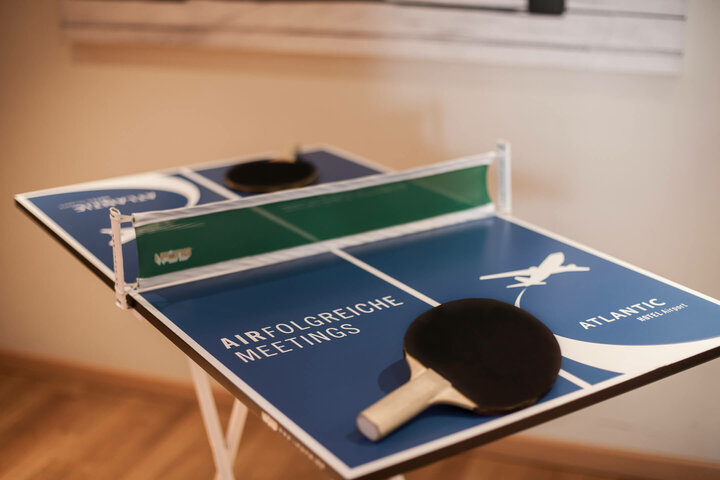 Table tennis at the ATLANTIC Hotel Airport Mini table tennis table at the ATLANTIC Hotel Airport Bremen with bats, blue playing field and green net.