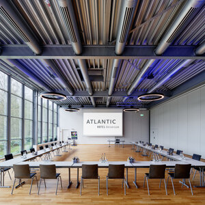 Moderner Konferenzraum im ATLANTIC Hotel Universum mit großen Fenstern und Tagungstischen.
