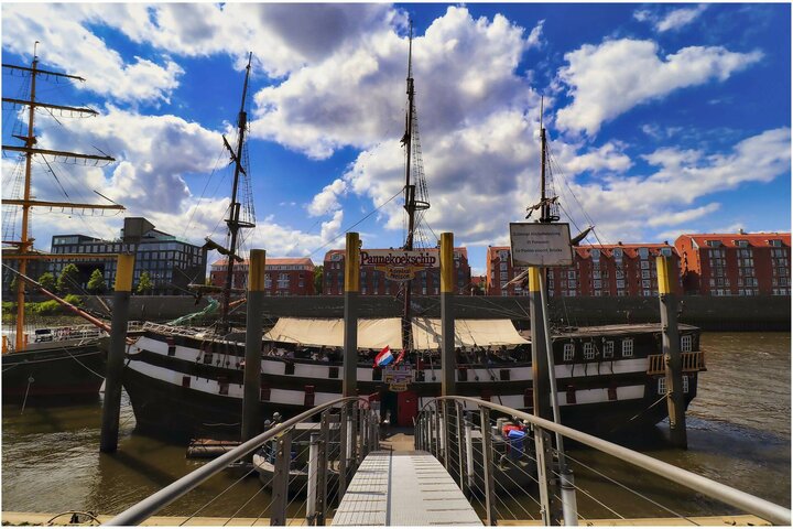 Ship at the Schlachte in Bremen Historic sailing ship in the harbor, surrounded by brick buildings under a blue sky with clouds.