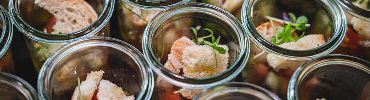 Small glasses with pieces of bread, salad and herbs, elegantly arranged at the ATLANTIC Hotel Heidelberg.