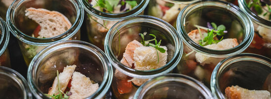 ATLANTIC Hotel Heidelberg Tagungen Speisen Kleine Gläser mit Brotstücken, Salat und Kräutern, elegant angerichtet im ATLANTIC Hotel Heidelberg.