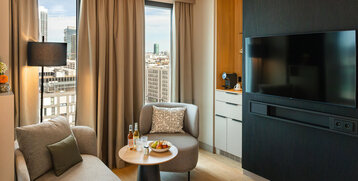 A seating area with a TV and coffee station in the Junior Suite.