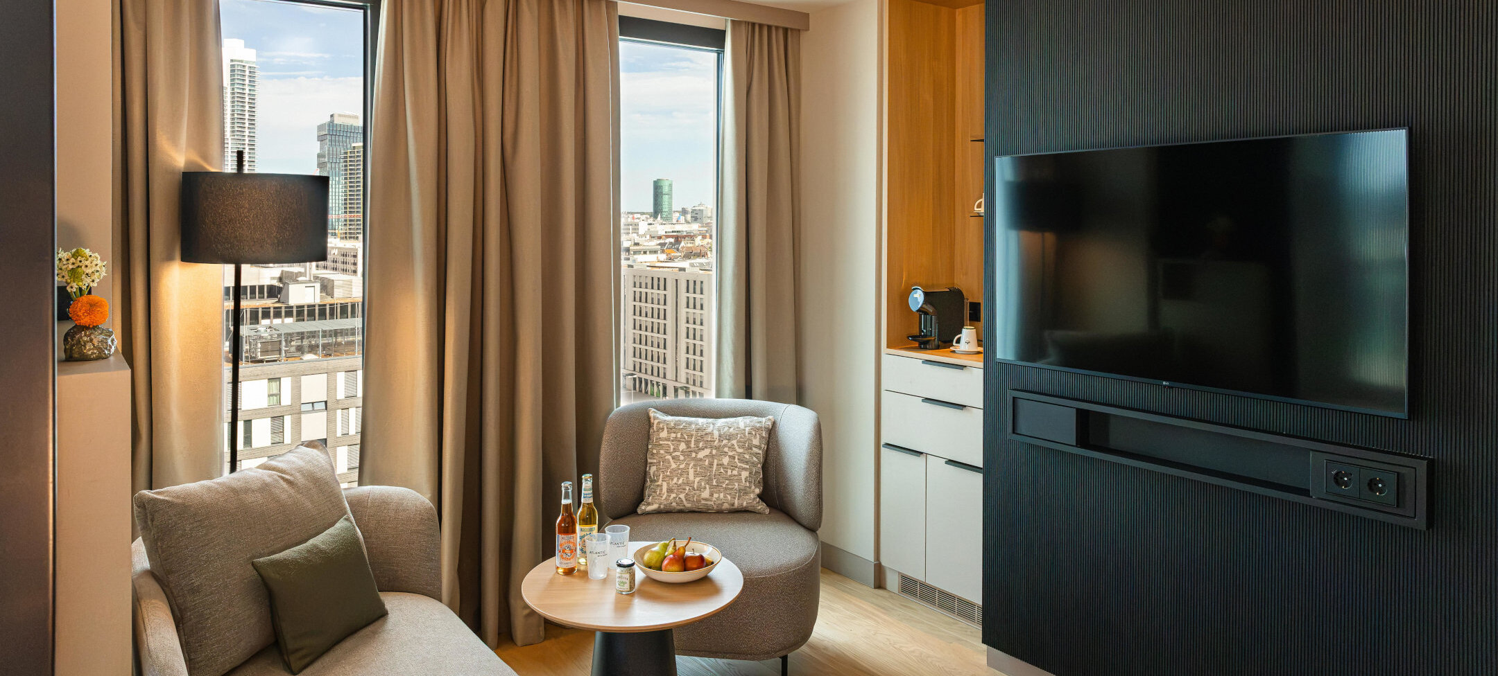 A seating area with a TV and coffee station in the Junior Suite.
