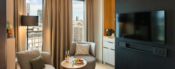 A seating area with a TV and coffee station in the Junior Suite.