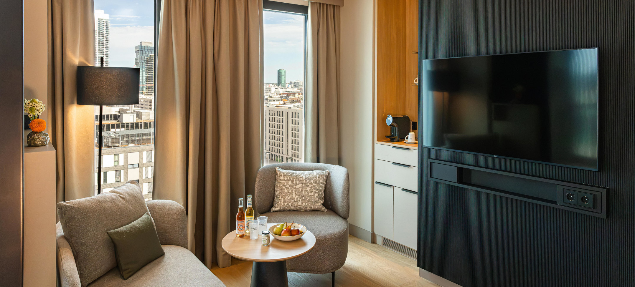 A seating area with a TV and coffee station in the Junior Suite.