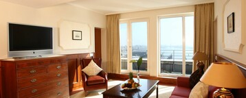 Living room of the Gorch Fock Suite with a sofa and flatscreen TV in the ATLANTIC Hotel Wilhelmshaven 