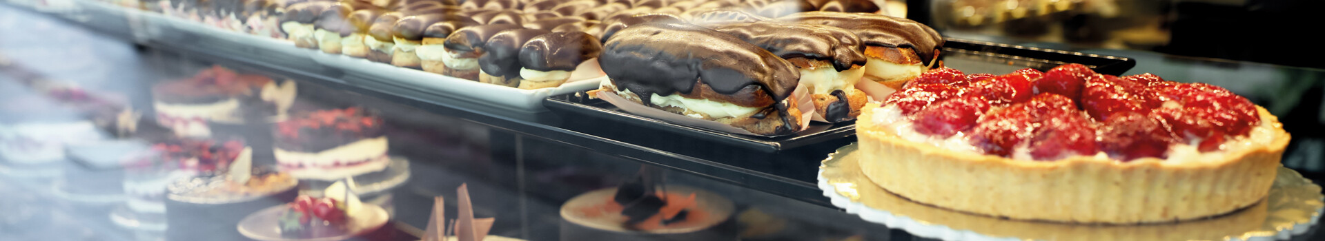 A display case with eclairs and a strawberry tart in the ATLANTIC Grand Hotel Travemünde.