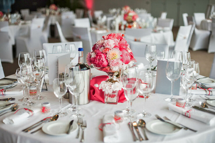 Elegant table setting with flower arrangements and glasses at the ATLANTIC Hotel Galopprennbahn Bremen.
