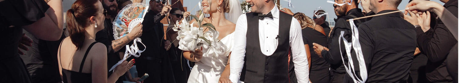 ATLANTIC Grand Hotel Bremen Weddings at the Grand Terrace Wedding couple leaving a festive outdoor ceremony beaming, surrounded by cheering guests with ribbons.
