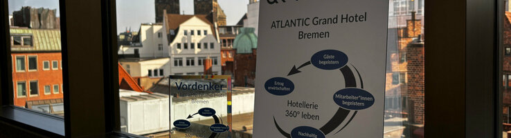 The 2025 Visionary Award on a windowsill, with the view from the hotel overlooking Bremen's St. Petri Cathedral in the background.
