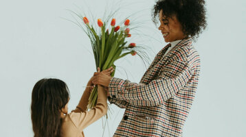 Kind schenkt Mutter Blumen 