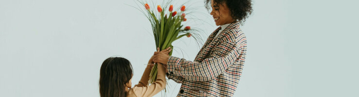 Kind schenkt Mutter Blumen 