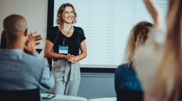Einer Tagungssprecherin wird applaudiert im Tagungsraum 