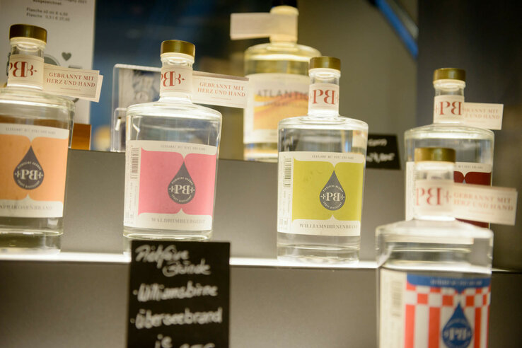 Various bottles of spirits with colorful labels on a shelf in the ATLANTIC Hotel Sail City.