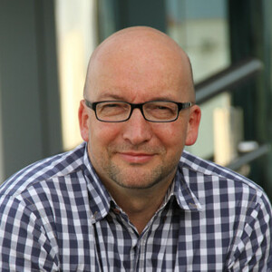 Herr mit Brille und Glatze im Karohemd