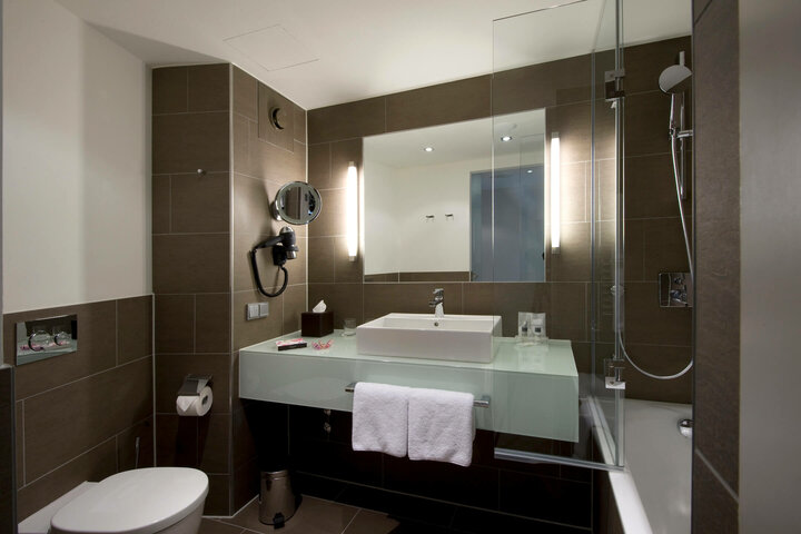 Bathroom superior room Modern hotel bathroom with glass washbasin, illuminated mirror, bathtub and towel rail at the ATLANTIC Grand Hotel Bremen.