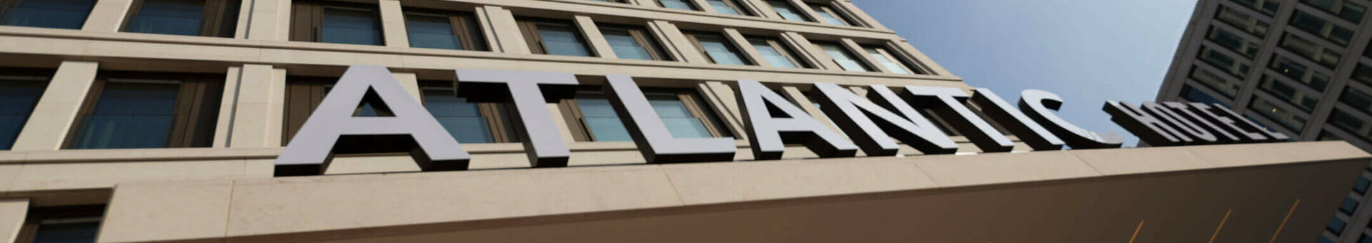 Fassade des ATLANTIC Hotel Heidelberg mit blauem Himmel im Hintergrund.
