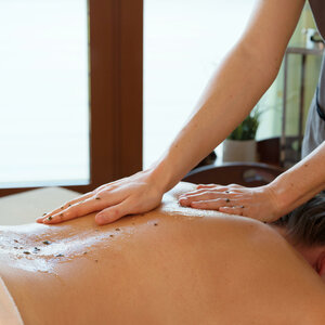 Rückenmassage im ATLANTIC Hotel Wilhelmshaven Person erhält entspannende Rückenmassage mit Peeling in einem Spa.
