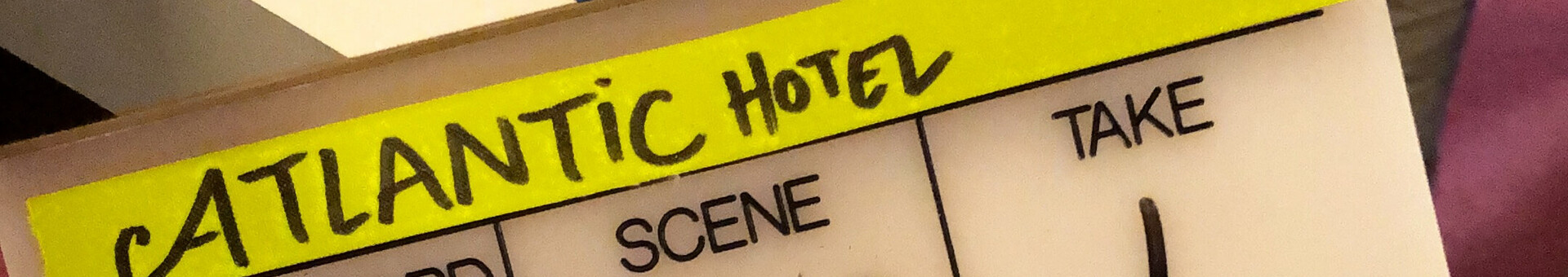 Filmklappe mit gelbem Aufkleber, Aufschrift "Atlantic Hotel", darunter Szenen- und Take-Nummern.