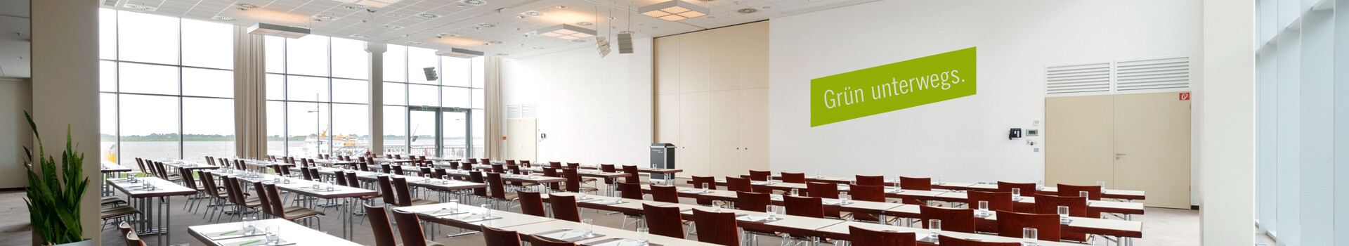 ATLANTIC Hotel SAIL City Heller Konferenzraum im ATLANTIC Hotel Sail City mit Blick auf das Wasser, Tische und Stühle in Reihen angeordnet.