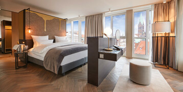 Modern hotel room at the ATLANTIC Grand Hotel Bremen with double bed, stylish furnishings and a view of the city.