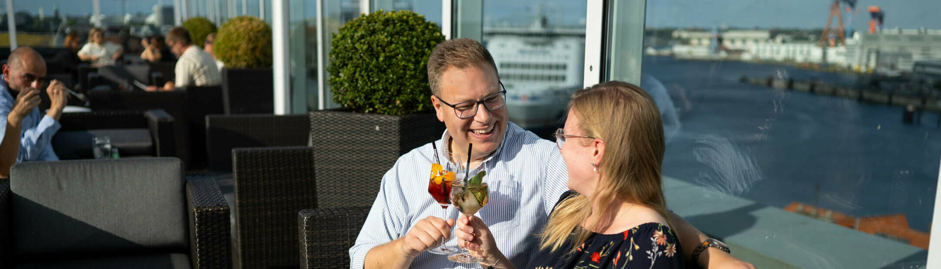 Anstoßen bei Sonne auf der Dachterrasse von der Bar Deck 8